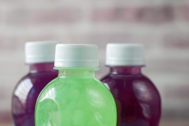 Plastic bottles of soft drink on table