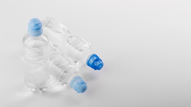 Photo plastic bottles of water with blue caps copy space