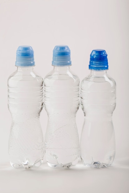 Plastic bottles of water with blue caps front view