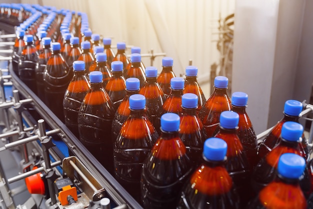 Plastic bottles with beer on a conveyor belt.