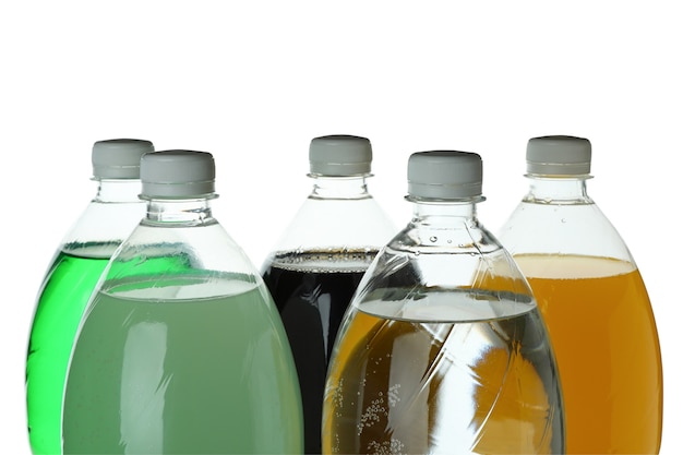 Plastic bottles with different soda isolated on white surface