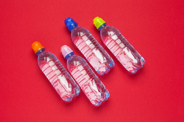 Plastic bottles with pure water on red 