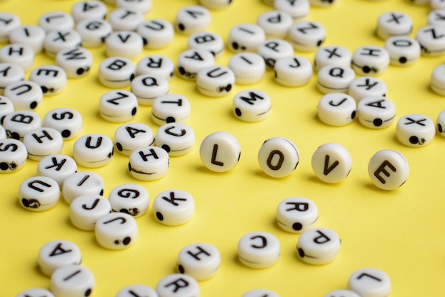 Plastic bricks make together word LOVE on yellow background