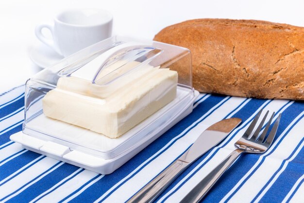 Plastic butter dish with butter on the kitchen tablecloth