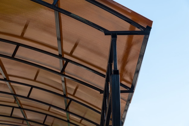 Plastic carport. brown transparent roof made of polycarbonate with metal structures