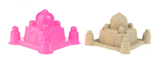 白い背景に分離されたプラスチック製の城と砂の彫刻