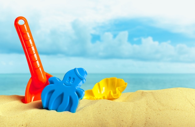 Photo plastic children toys on the sand beach