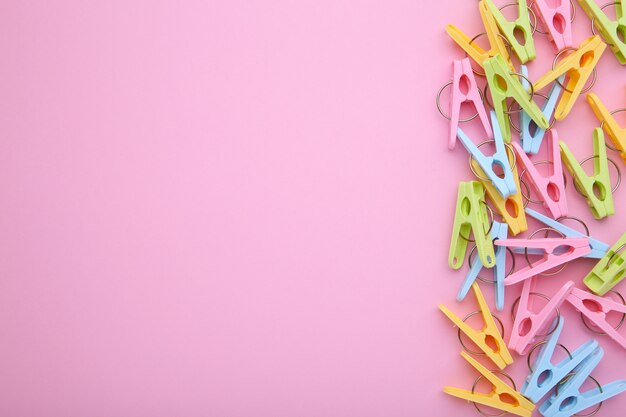 Plastic clothes pins on a pink background