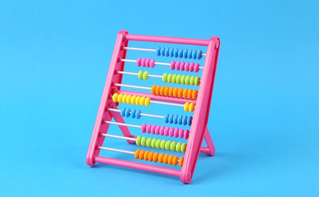 Photo plastic colored abacus on a blue background counting education economy business and finance concept