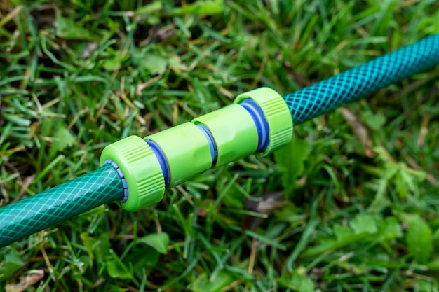급수 호스용 플라스틱 커넥터는 녹색 잔디에 있습니다.