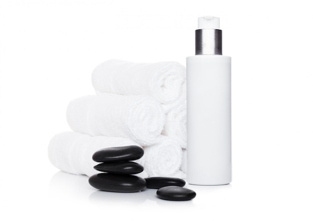 Plastic container of skin cream with spa towels