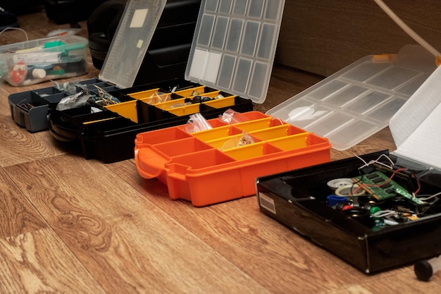 Plastic containers with tools on a wooden floor