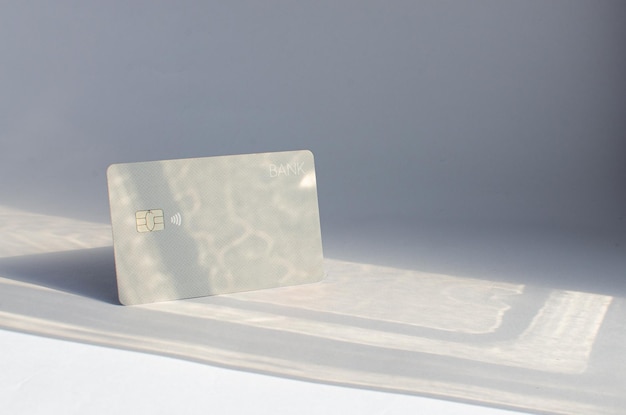 テーブルの上にチップが見えるプラスチック製のクレジットカードで、表面に柔らかな光と影があります。
