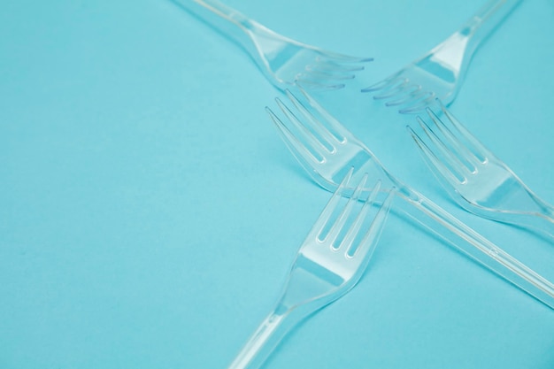 Photo plastic cutlery forks arranged on a blue background plastic waste problem