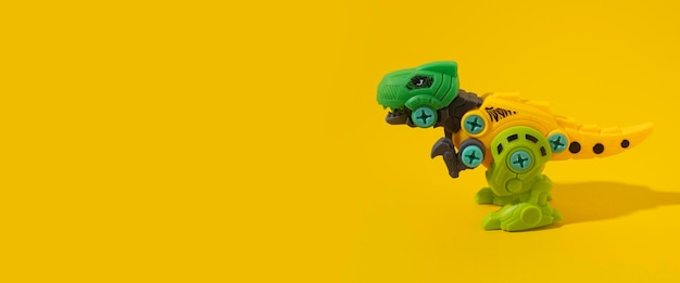 Plastic dinosaur toy on yellow background Banner