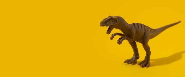 Plastic dinosaur toy on yellow background Banner