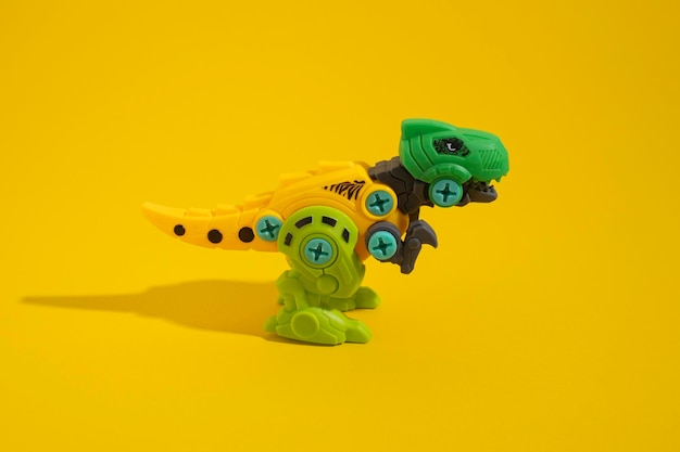 Plastic dinosaur toy on yellow background