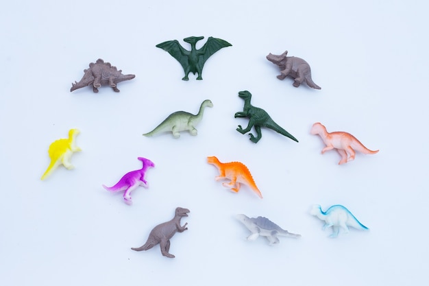 白い背景の上のプラスチック製の恐竜のおもちゃ。上面図
