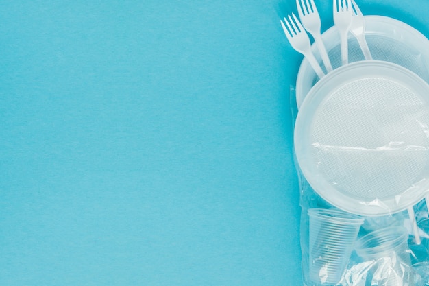 Photo plastic dishes on a blue wall. disposable tableware