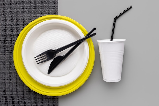 Plastic disposable tableware. food plastic on a gray\
background, top view.