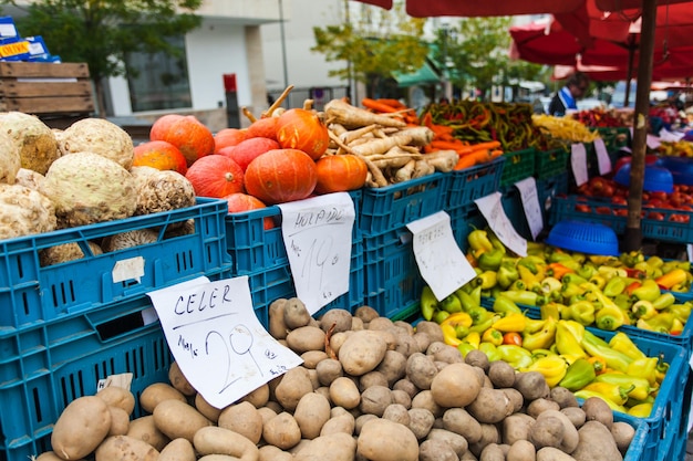 Plastic dozen met aardappelen, paprika's en andere groenten op het aanrecht.