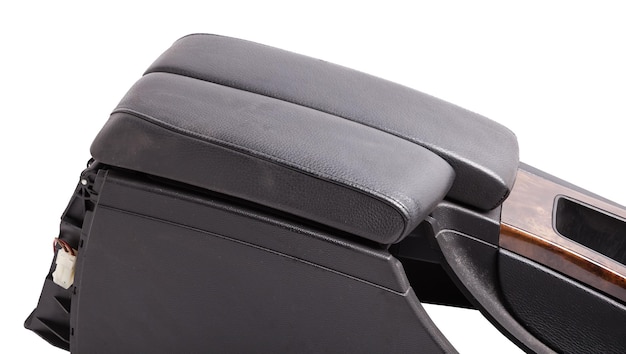 Plastic element of car interior is covered in black leather and wooden armrest or a glove compartment spare part with air conditioning holes on a white background Catalog for site