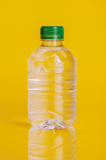 Plastic fles mineraalwater op een heldere gele achtergrond