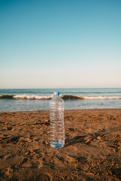 Plastic fles verlaten op het strand in de Middellandse Zee.