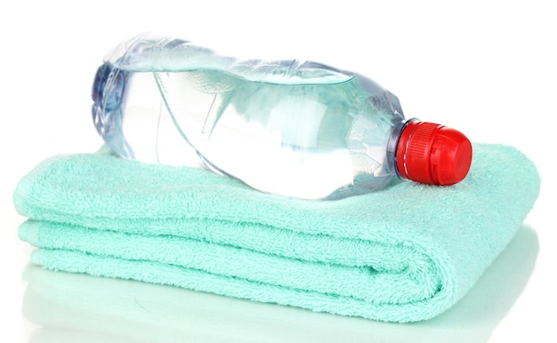 Plastic fles water op handdoek op wit wordt geïsoleerd