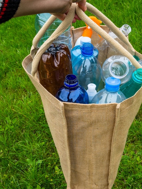 Plastic flessen in een milieuvriendelijke tas om te winkelen in handlinnen jute netzak Zero waste achtergrond