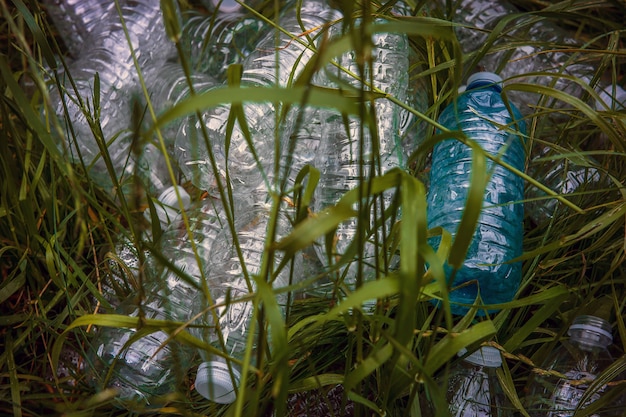 Foto plastic flessen in het groene gras. probleem in de natuurlijke omgeving.