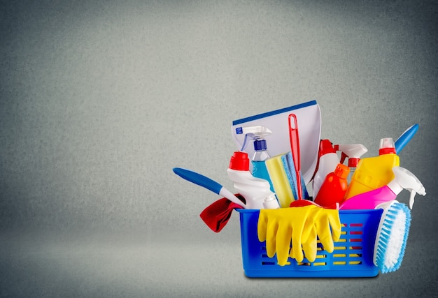 Plastic flessen, reinigingssponzen en handschoenen op achtergrond