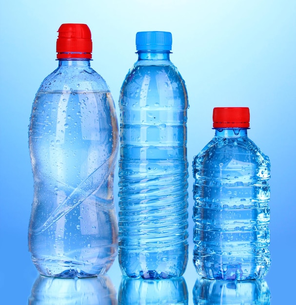 Plastic flessen water op blauwe achtergrond