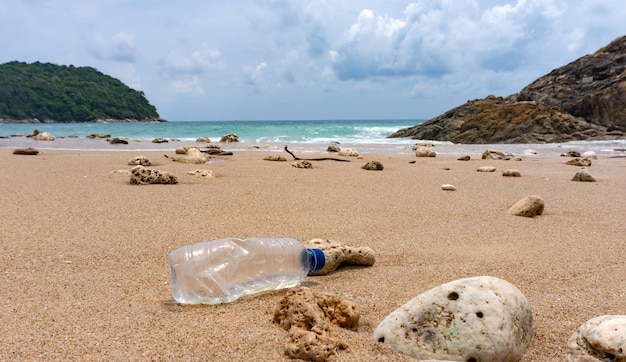 Plastic flessenafval is een milieuvervuiling op het strand.