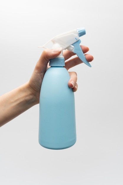 白い背景に分離された手にプラスチック霧スプレー ボトル