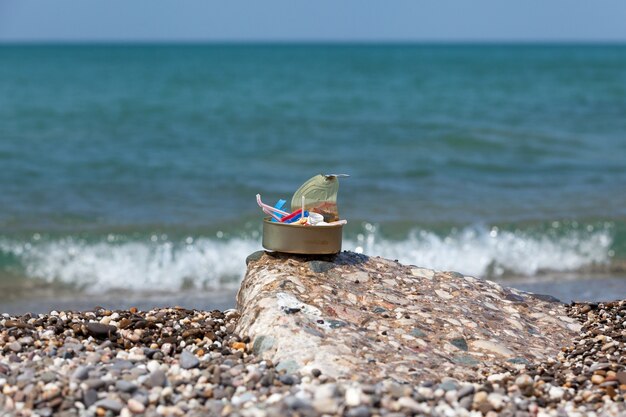 Plastic garbage collected on seashore in tin can Excessive consumption of disposable packaging