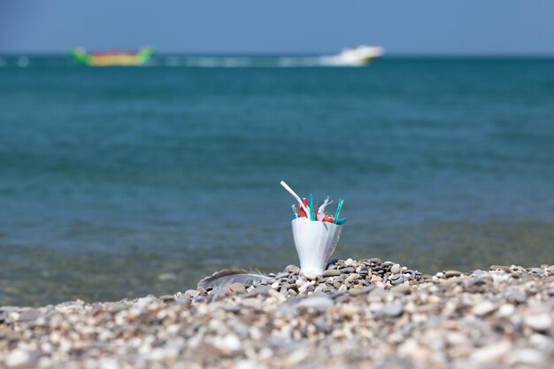 海岸のプラスチックごみ家庭ごみと使い捨てのプラスチックごみが浜辺に残されている