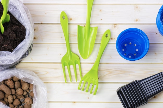 Plastic garden tools  a shovel a rake and plastic containers for seedlings