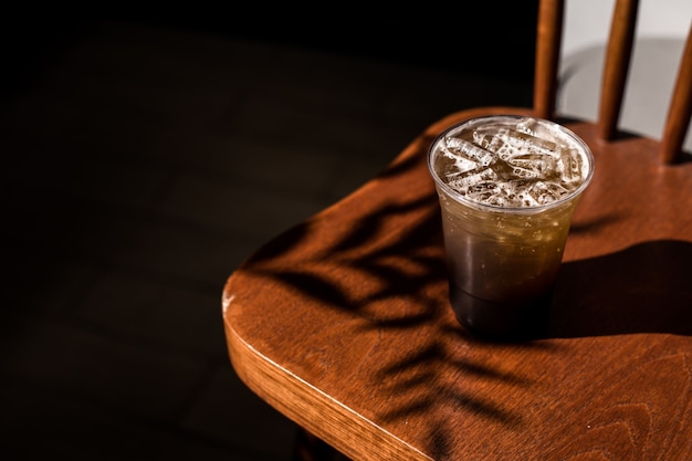 Plastic glas ijskoffie met sprankelende frisdrank op tafel