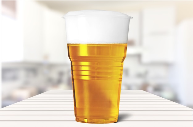 Foto plastic glas met bier op tafel