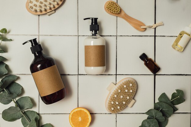 Plastic and glass brown bottles with eco friendly organic cosmetics, green eucalyptus and cut oranges from above. Beauty minimalism concept. Natural cosmetics ingredients for skin care.