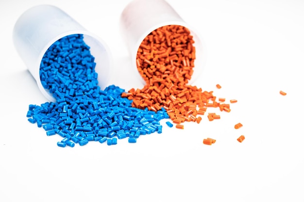 Foto granuli di plastica da vicino per contenere, granuli di plastica colorati con sfondo bianco.