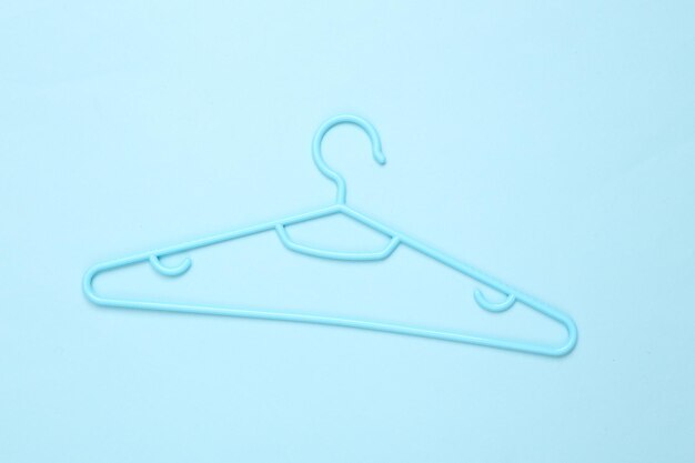 Plastic hanger on a blue background Fashion layout Flat lay Top view