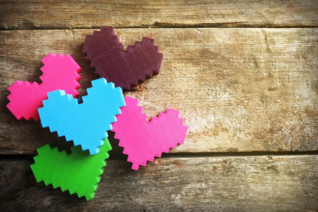 Plastic hearts on wooden background