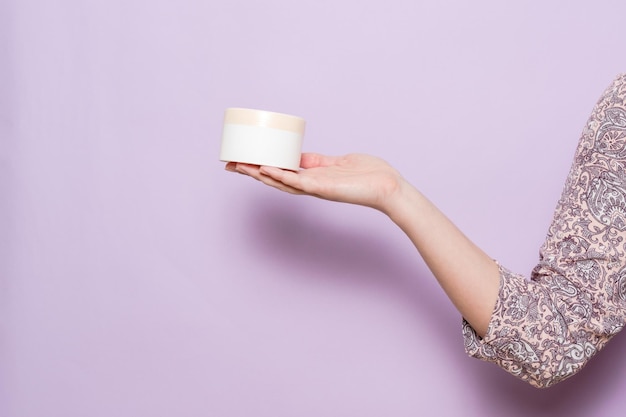 A plastic jar container for cream in a woman's hand Cosmetic product