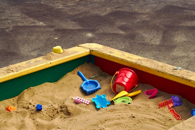 Foto plastic kinderspeelgoed in zandbak op speelplaats