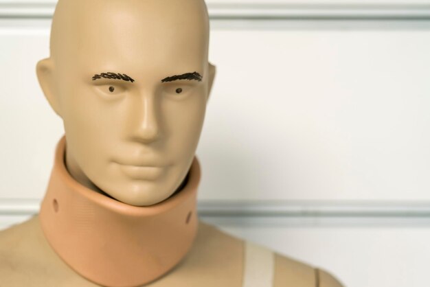 Plastic male mannequin against a white wall