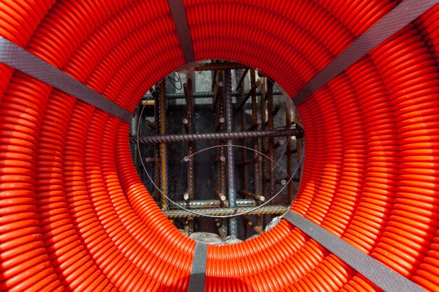 plastic orange hose is wrapped in a coil on a construction site