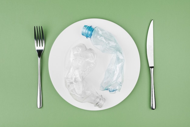 Plastic and organic garbage on the plate, concept of bad and unhealthy food