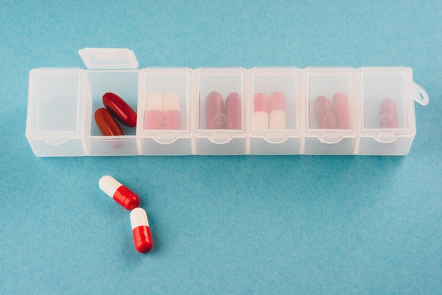 plastic organizer pill box for the week white color isolated on a blue background